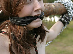 Outdoors Pictures -  Young slave is roped and chained outdoors with clips on her nipples